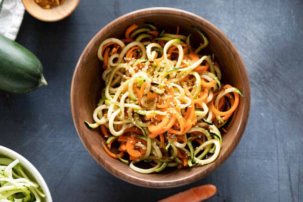 wooden bowl filled with Korean Cucumber Salad with spiralized cucumbers and carrots