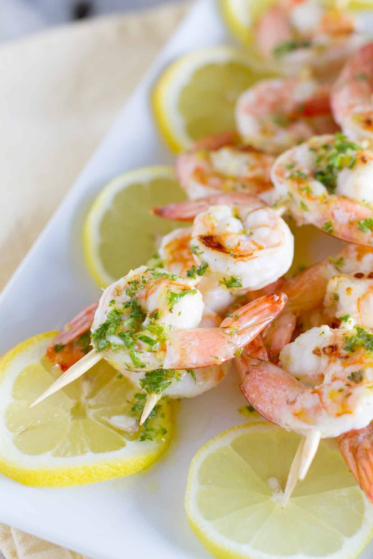 Lemon Shrimp Kabobs on top of lemon slices.