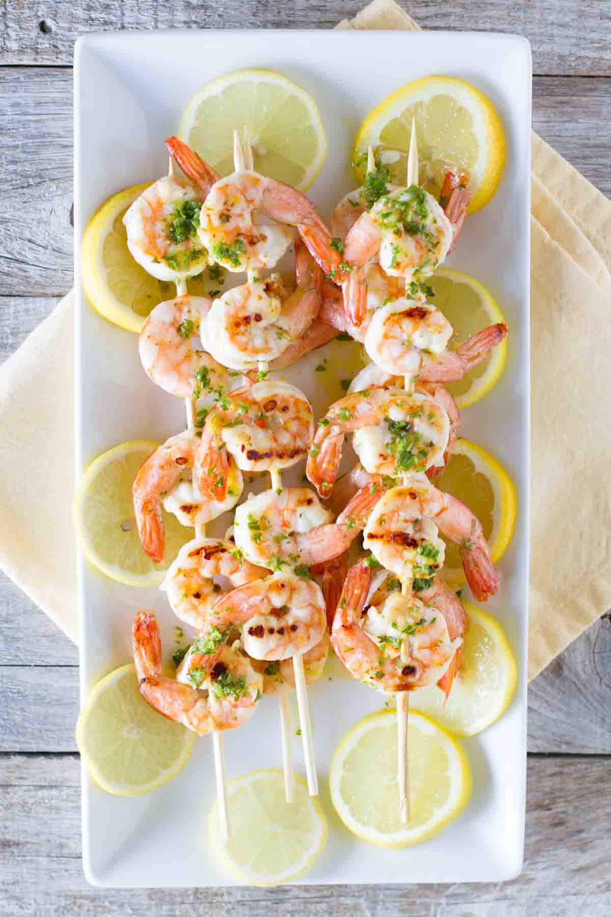 Grilled lemon shrimp on kabob sticks with lemon slices.