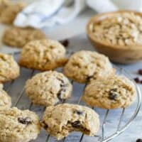 Oatmeal cookies on a cooling rack with a bite taken from one cookie