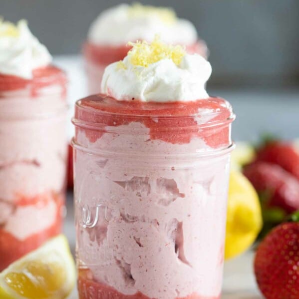 strawberry mousse topped with whipped cream in a jar