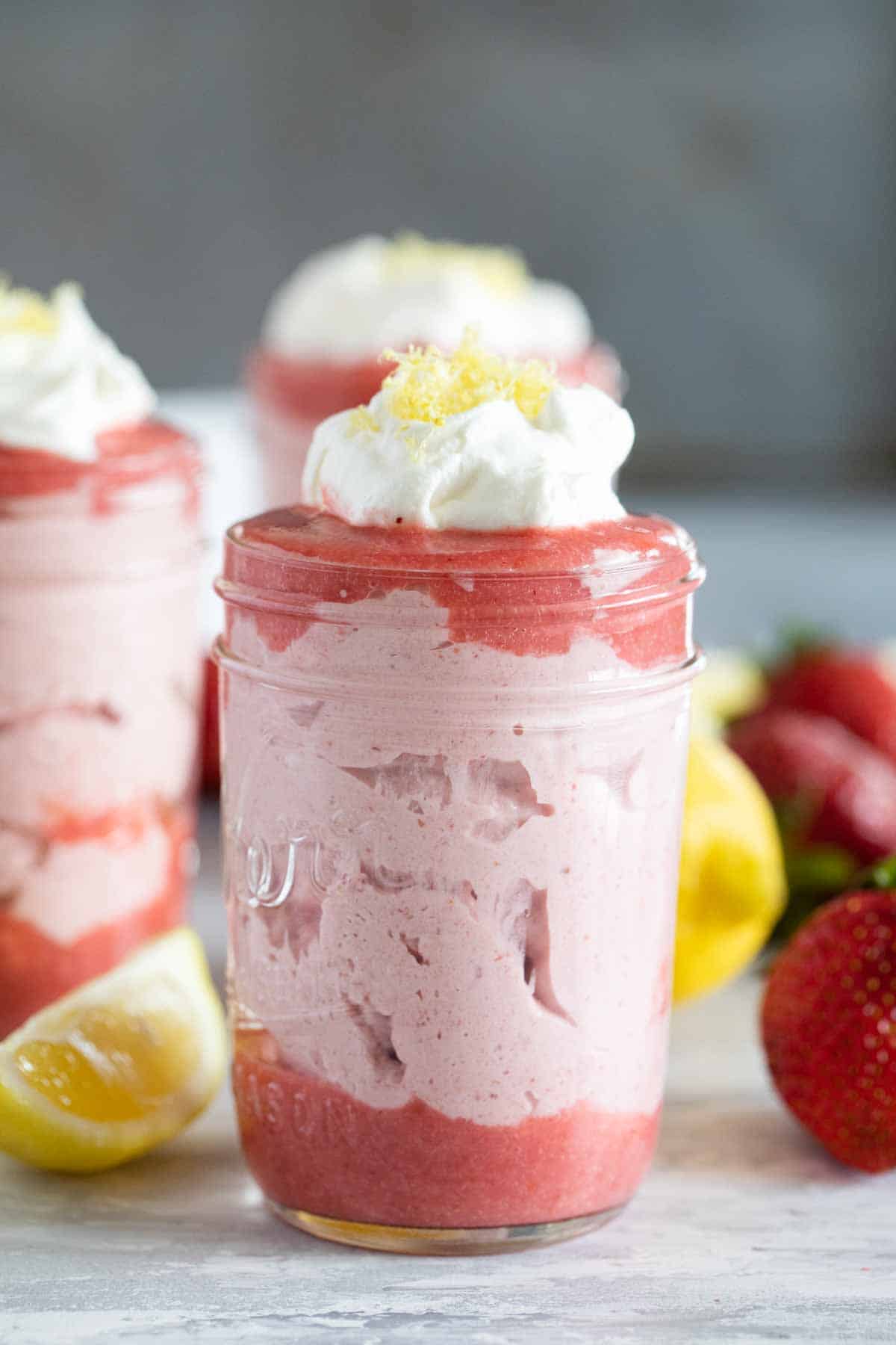 strawberry mousse topped with whipped cream in a jar