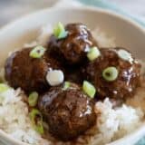 sweet and sour meatballs over rice topped with green onion