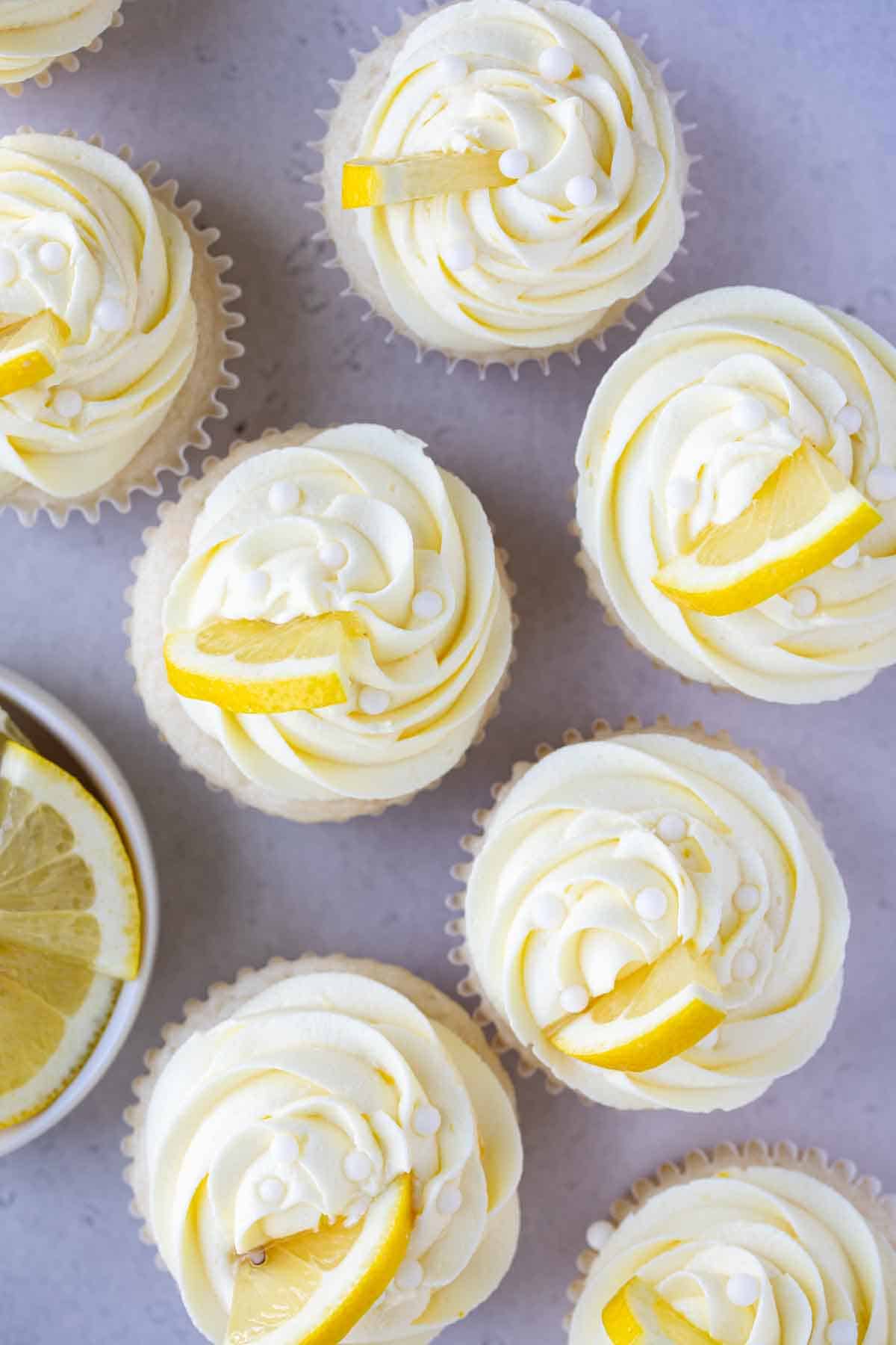 swirls of lemon buttercream frosting with white pearls and lemon slices