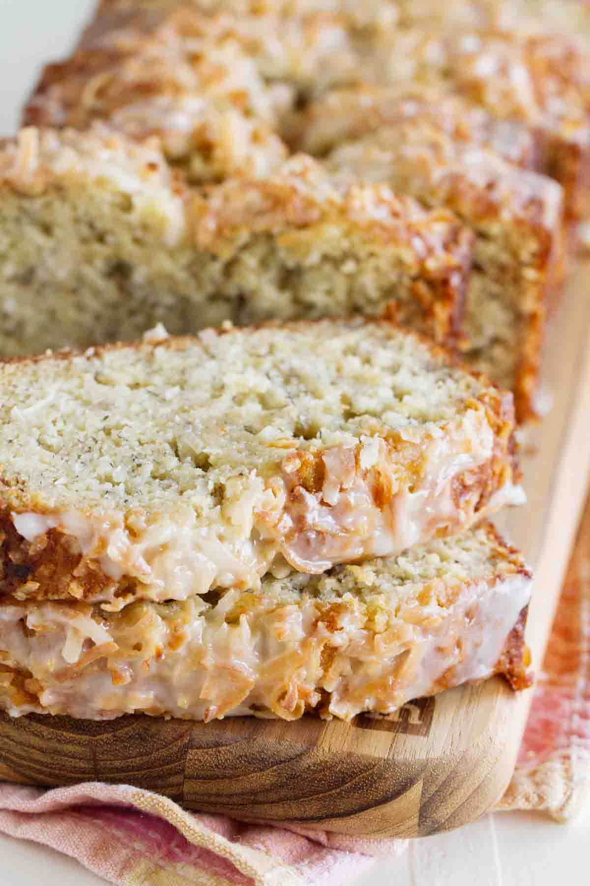 banana bread with coconut and a citrus glaze sliced and stacked