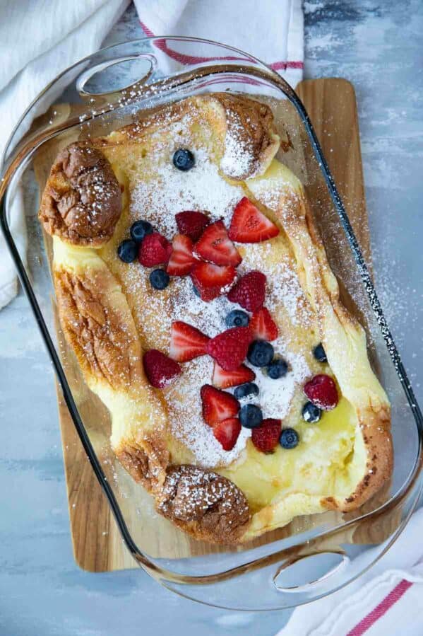 top view of Dutch baby in a glass baking dish with berries