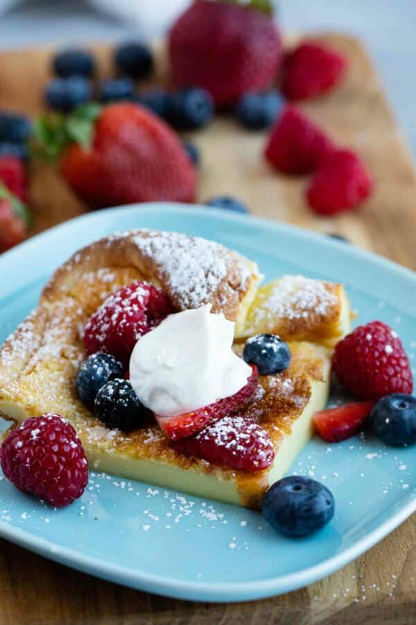 slice of a Dutch Baby topped with berries and whipped cream