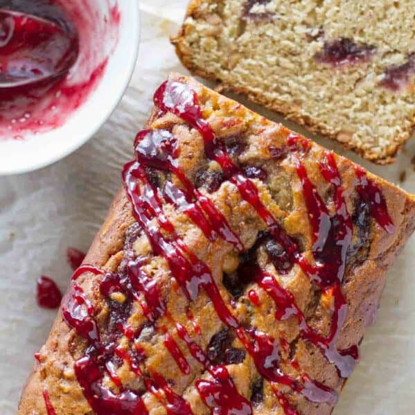 loaf of peanut butter and jelly banana bread with jelly drizzled on top