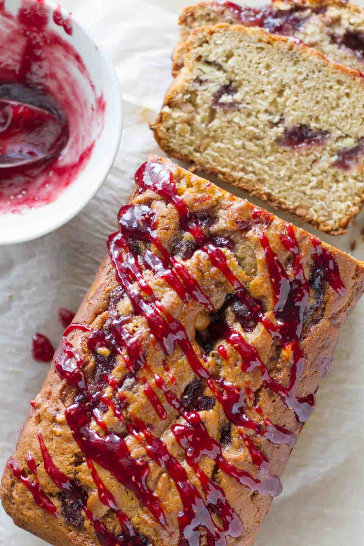 loaf of peanut butter and jelly banana bread with jelly drizzled on top