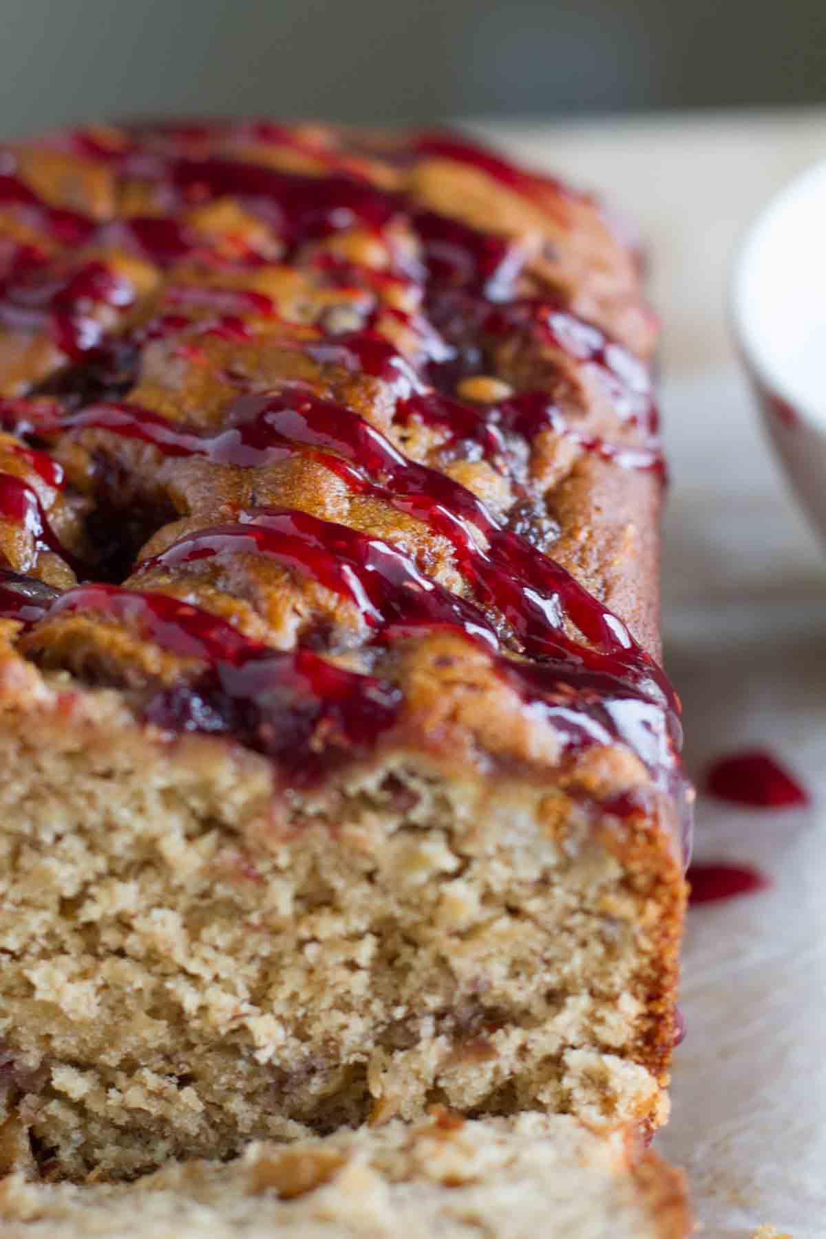 jelly drizzled on top of a loaf of peanut butter and jelly banana bread.