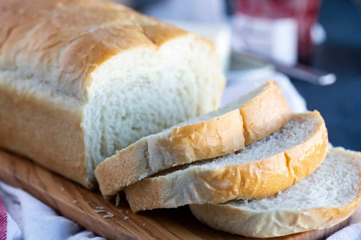 This may be the perfect sandwich bread! This Potato Bread is made with mashed potatoes which make for a loaf of bread that is sturdy, yet soft and fluffy. sliced loaf of potato bread on a cutting board