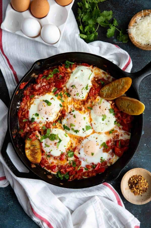 Cast iron skillet with eggs poached in tomato sauce for shakshuka