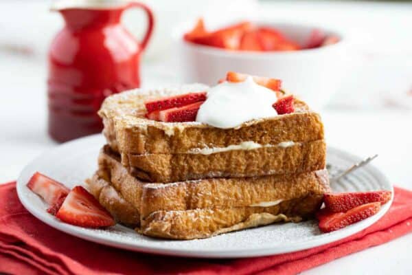 Plate with two servings of Stuffed French Toast with strawberries and whipped cream