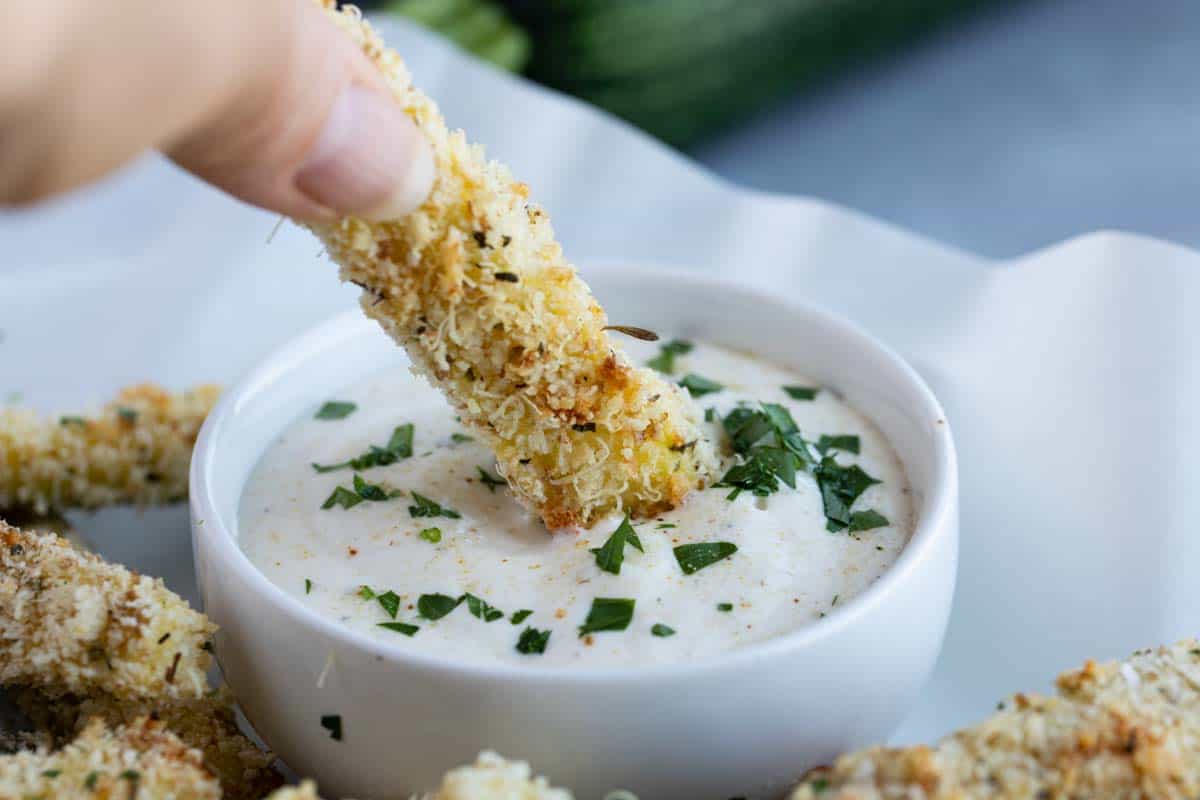 dipping a zucchini fry into ranch