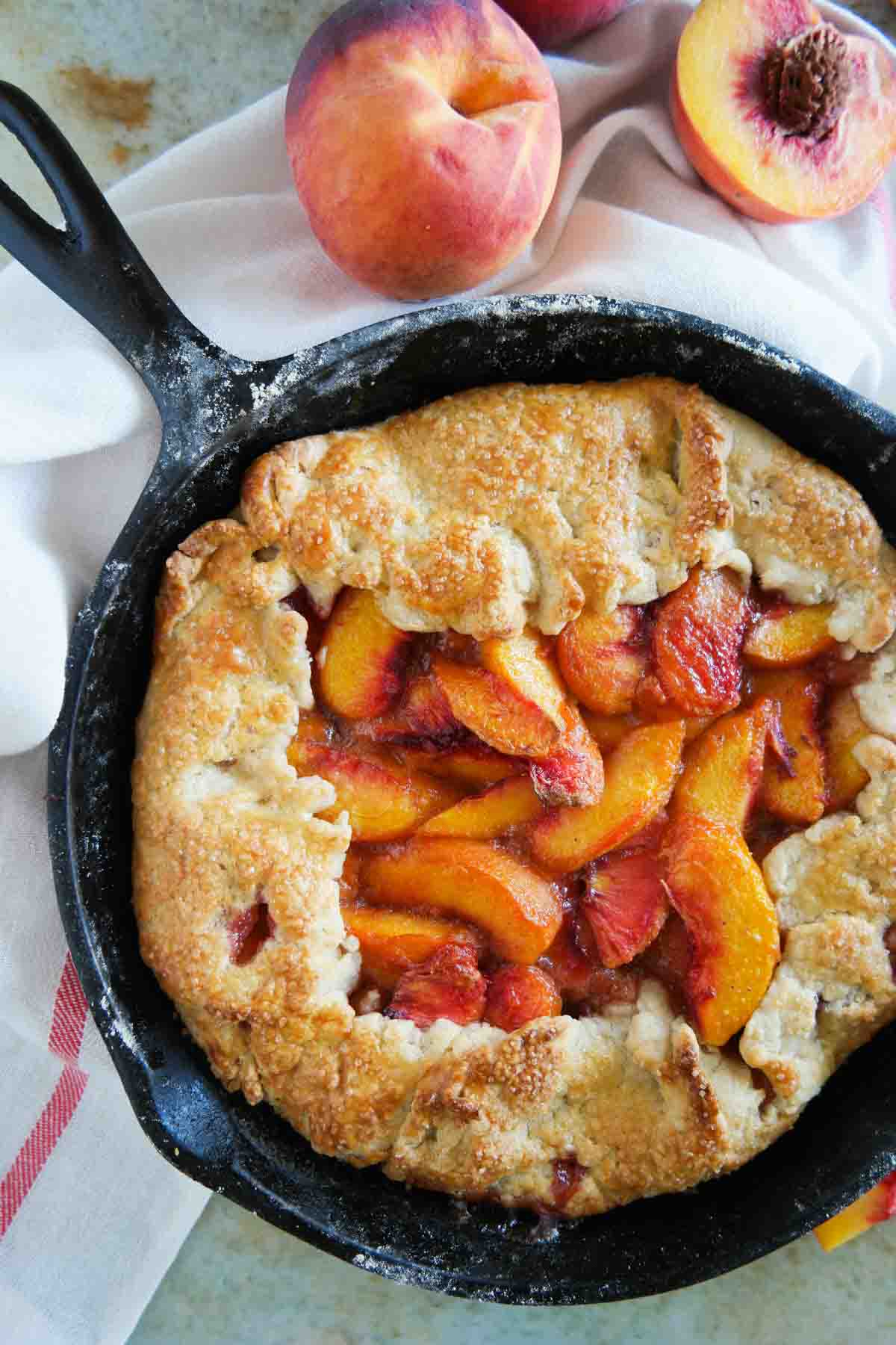 full peach crostata in a cast iron skillet