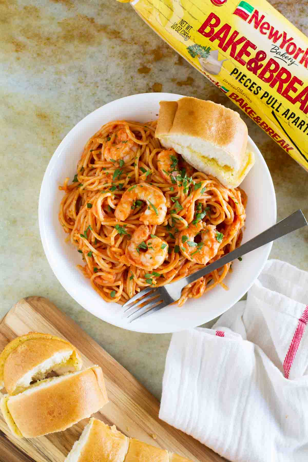 Creamy Shrimp and Tomato Pasta in a bowl with garlic bread surrounding