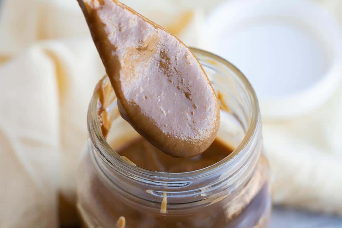 Jar filled with Peanut Sauce with a spoon