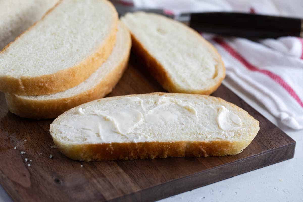 sliced loaf of Peasant Bread with butter on one slice