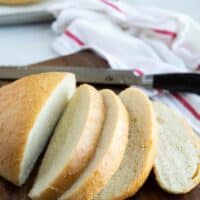 Round of sliced peasant bread on a cutting board