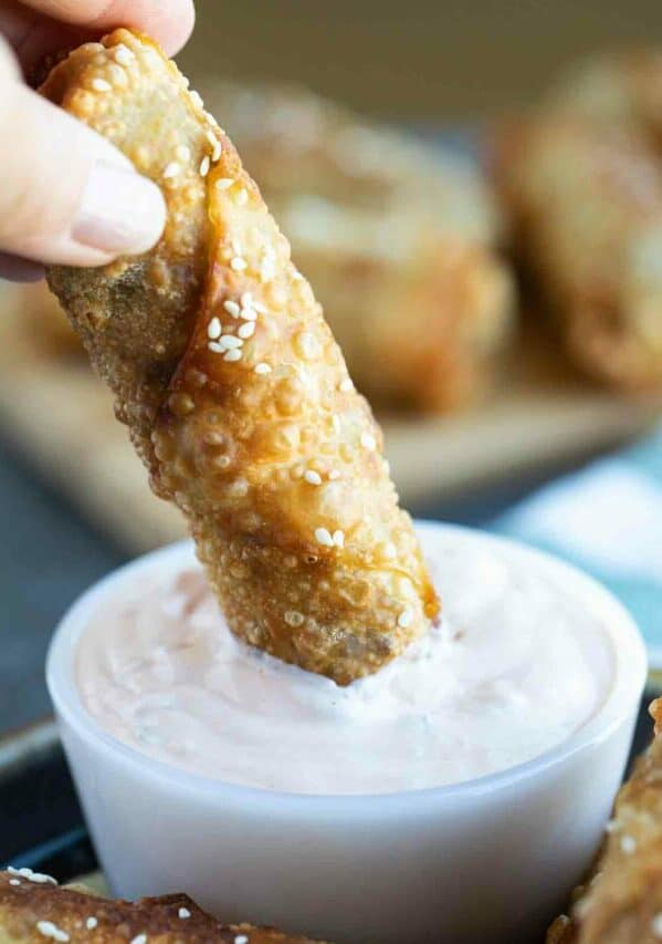 dipping a cheeseburger eggroll into sauce