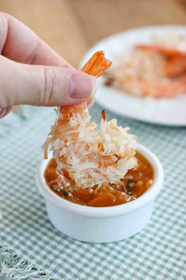 Dipping a baked coconut shrimp into basil peach sauce.