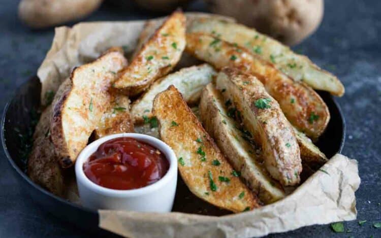 Baked JoJo Potatoes, or baked potato wedges, served with ketcup.