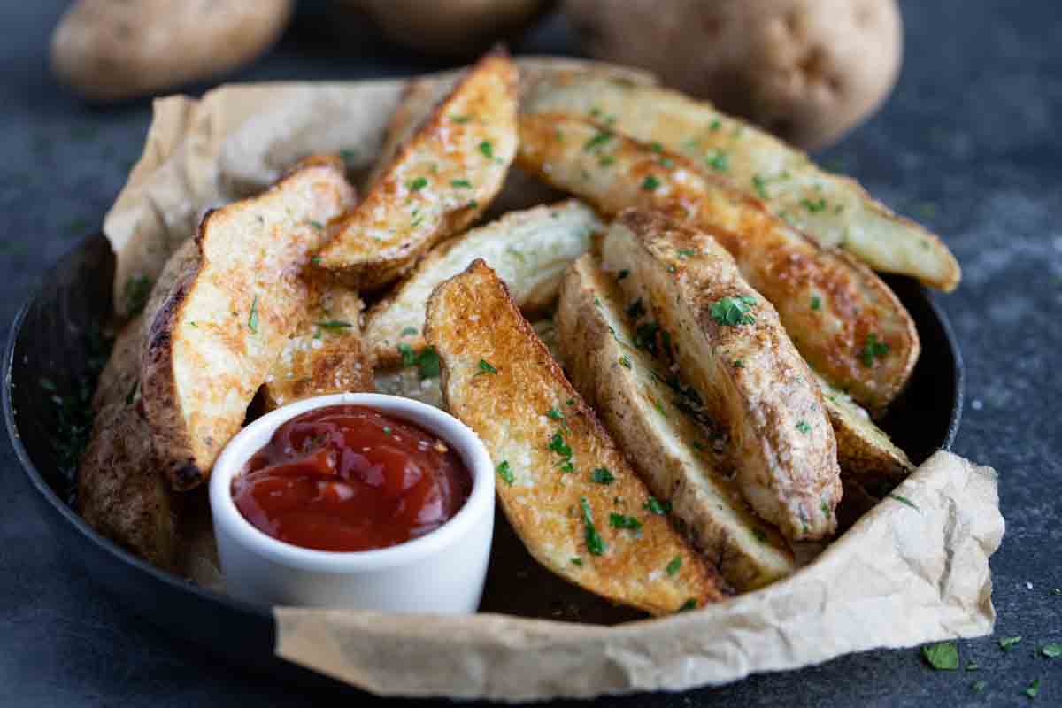 Baked JoJo Potatoes, or baked potato wedges, served with ketcup.