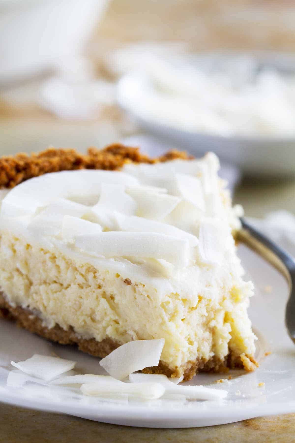 slice of Coconut Cheesecake Pie with a bite taken from it.