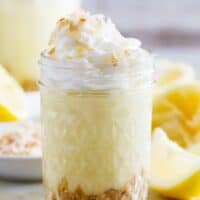 glass jar filled with Coconut Lemon Pudding Parfait topped with whipped cream.