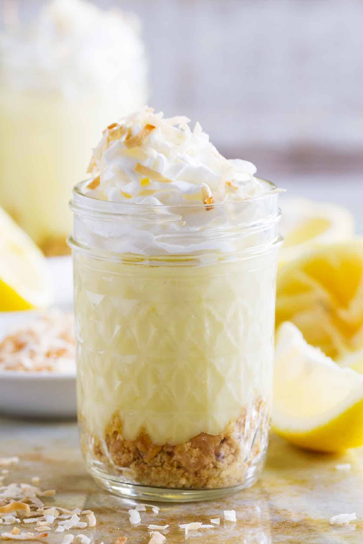 glass jar filled with Coconut Lemon Pudding Parfait topped with whipped cream.