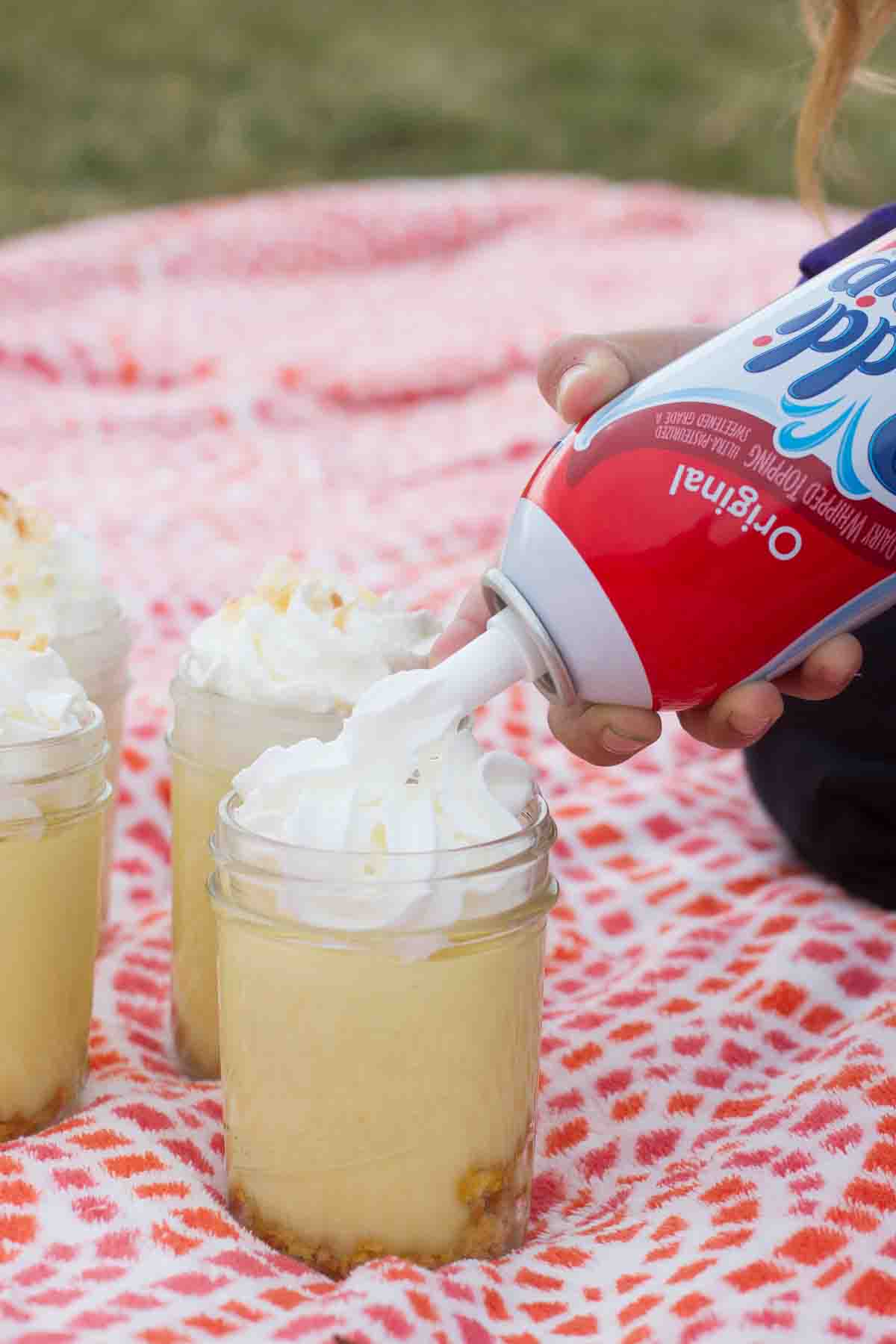 Topping a Coconut Lemon Pudding Parfait with Reddi Wip.