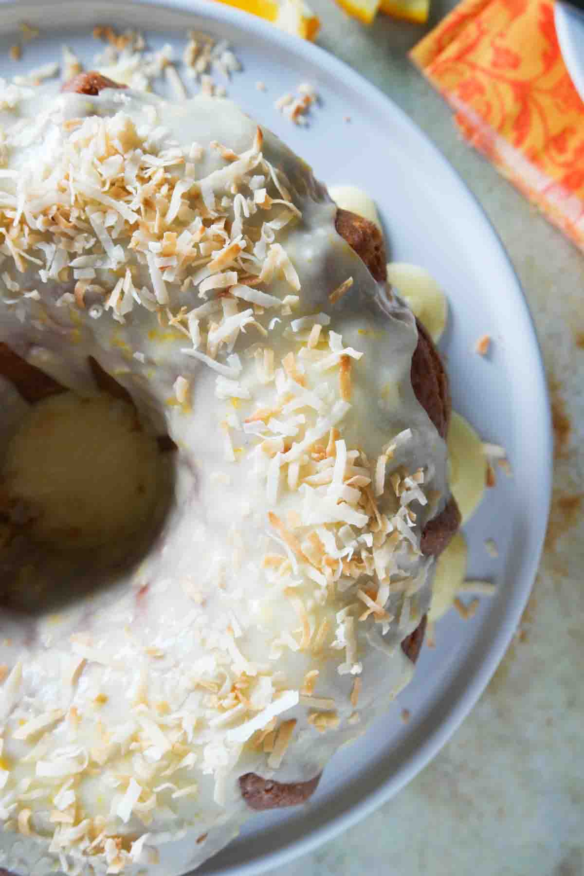 orange pound cake topped with icing and toasted coconut.