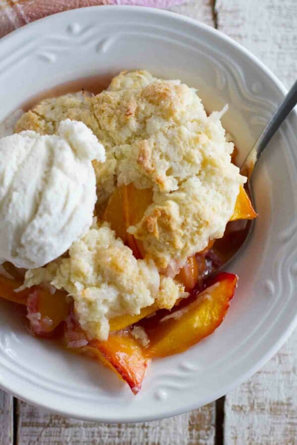 peach cobbler with coconut with a scoop of vanilla ice cream