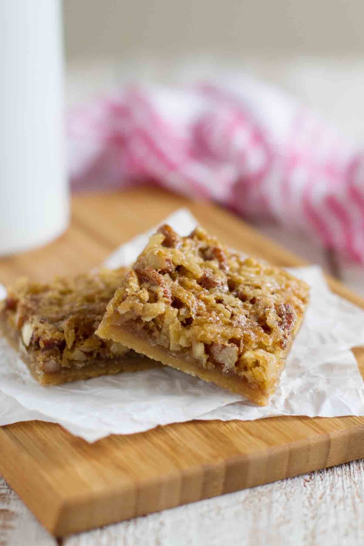 Two Coconut Pecan Bars on a cutting board.