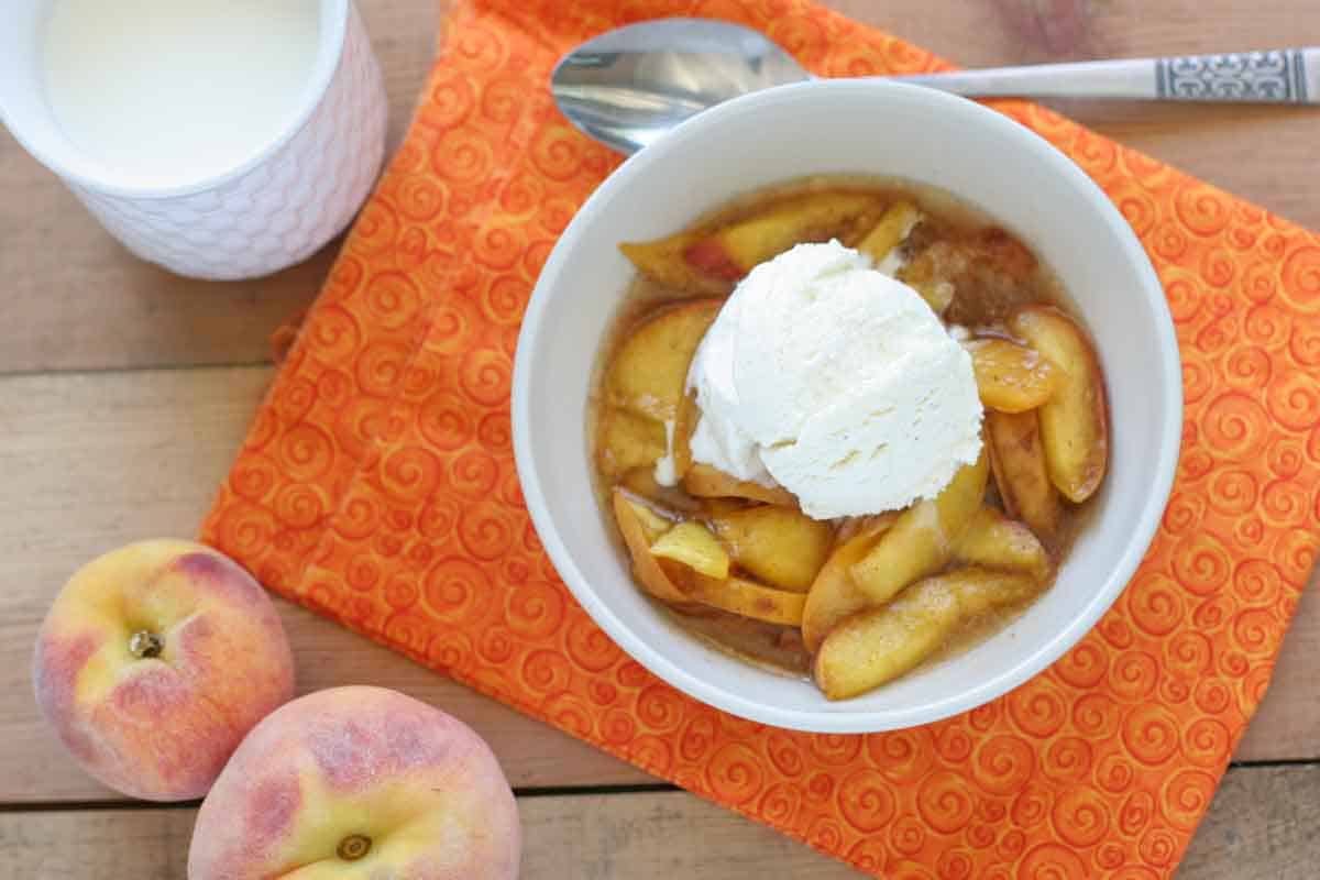 warm scalloped peaches cooked in the crock pot with ice cream