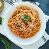 garlic spaghetti topped with parmesan and fresh basil