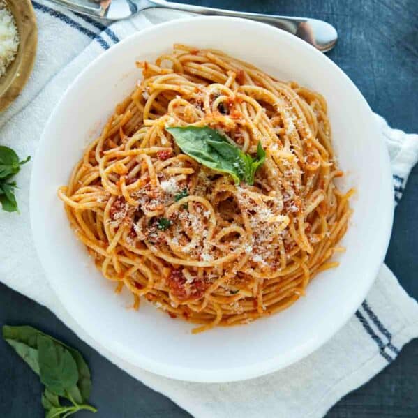 garlic spaghetti topped with parmesan and fresh basil