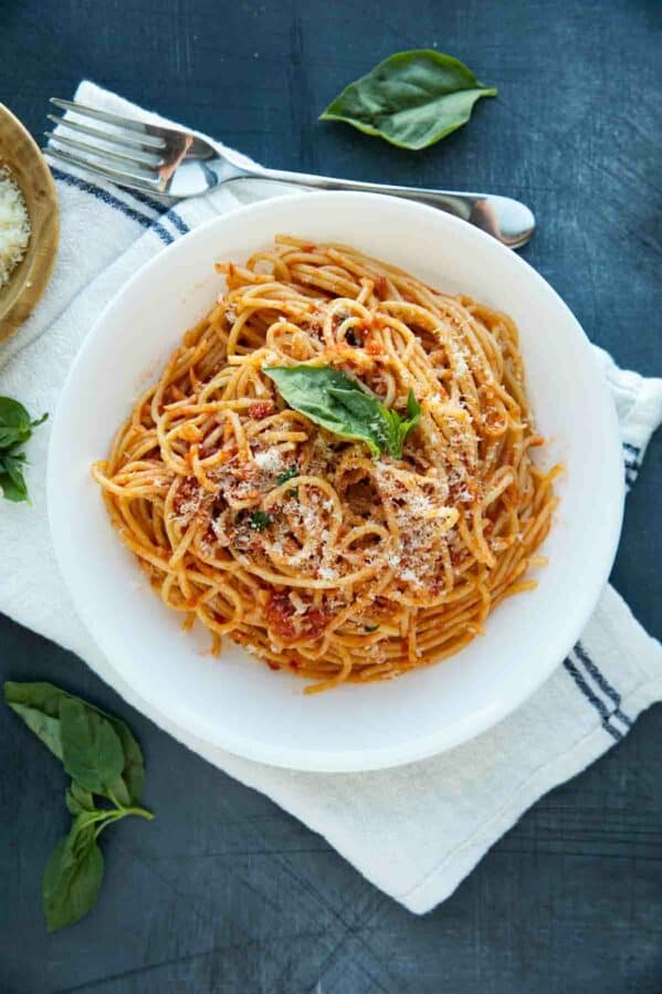 garlic spaghetti topped with parmesan and fresh basil
