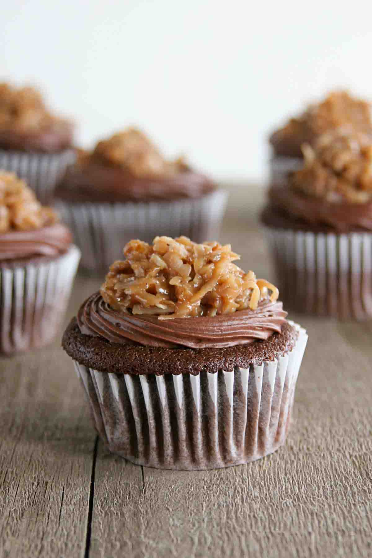 German chocolate cupcake topped with chocolate frosting and pecan frosting.