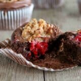 German Chocolate Cupcake with Raspberry Filling broken in half to show raspberry filling.
