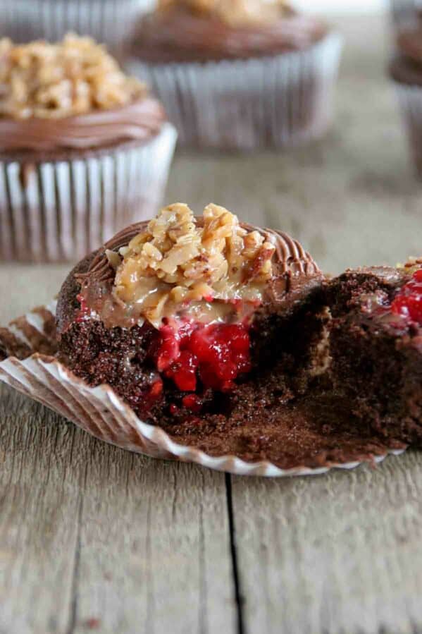 German Chocolate Cupcake with Raspberry Filling broken in half to show raspberry filling.