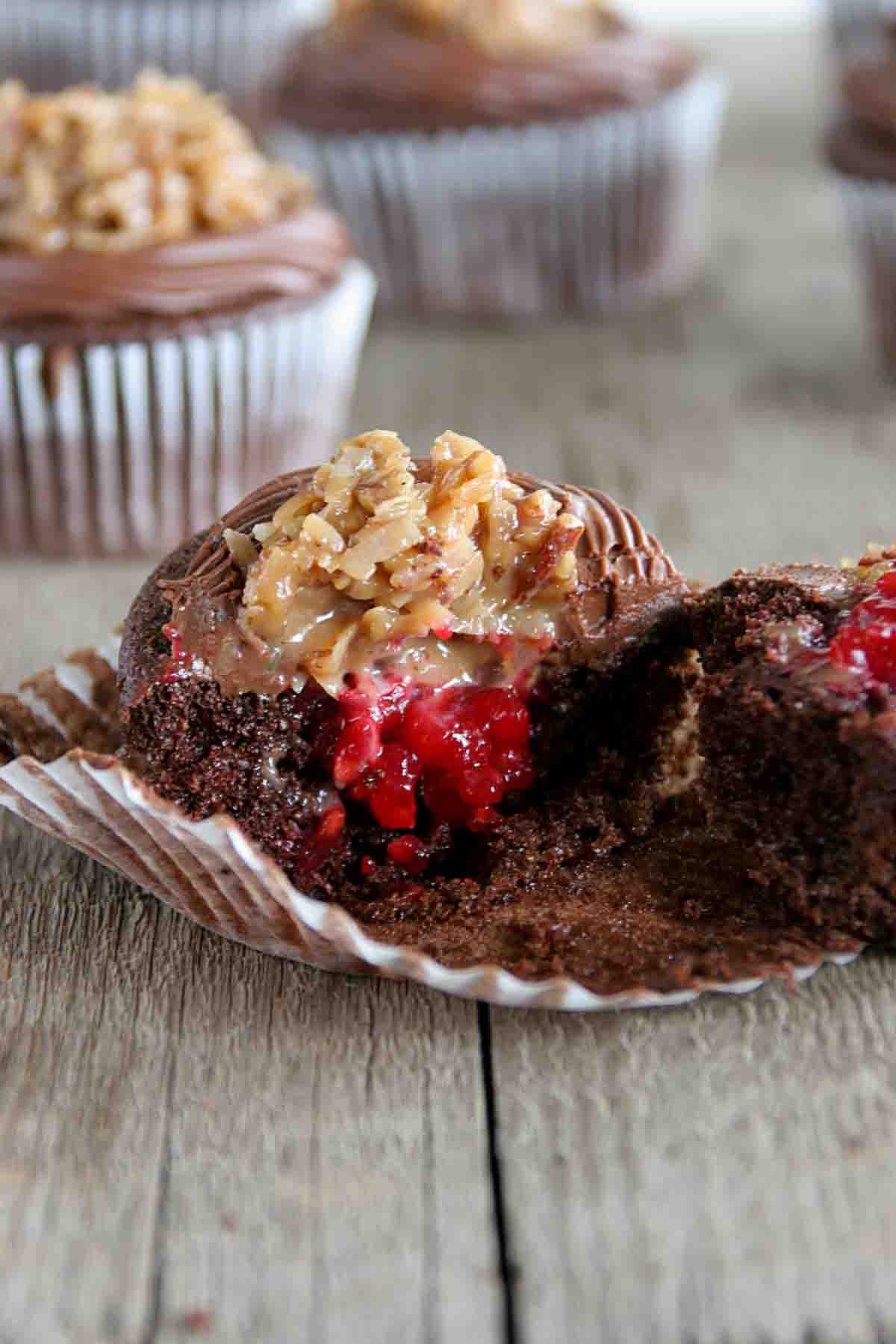 German Chocolate Cupcake with Raspberry Filling broken in half to show raspberry filling.
