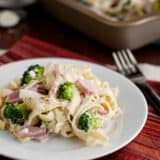 Ham and Broccoli Pasta Bake on a plate with the baking dish in the back.
