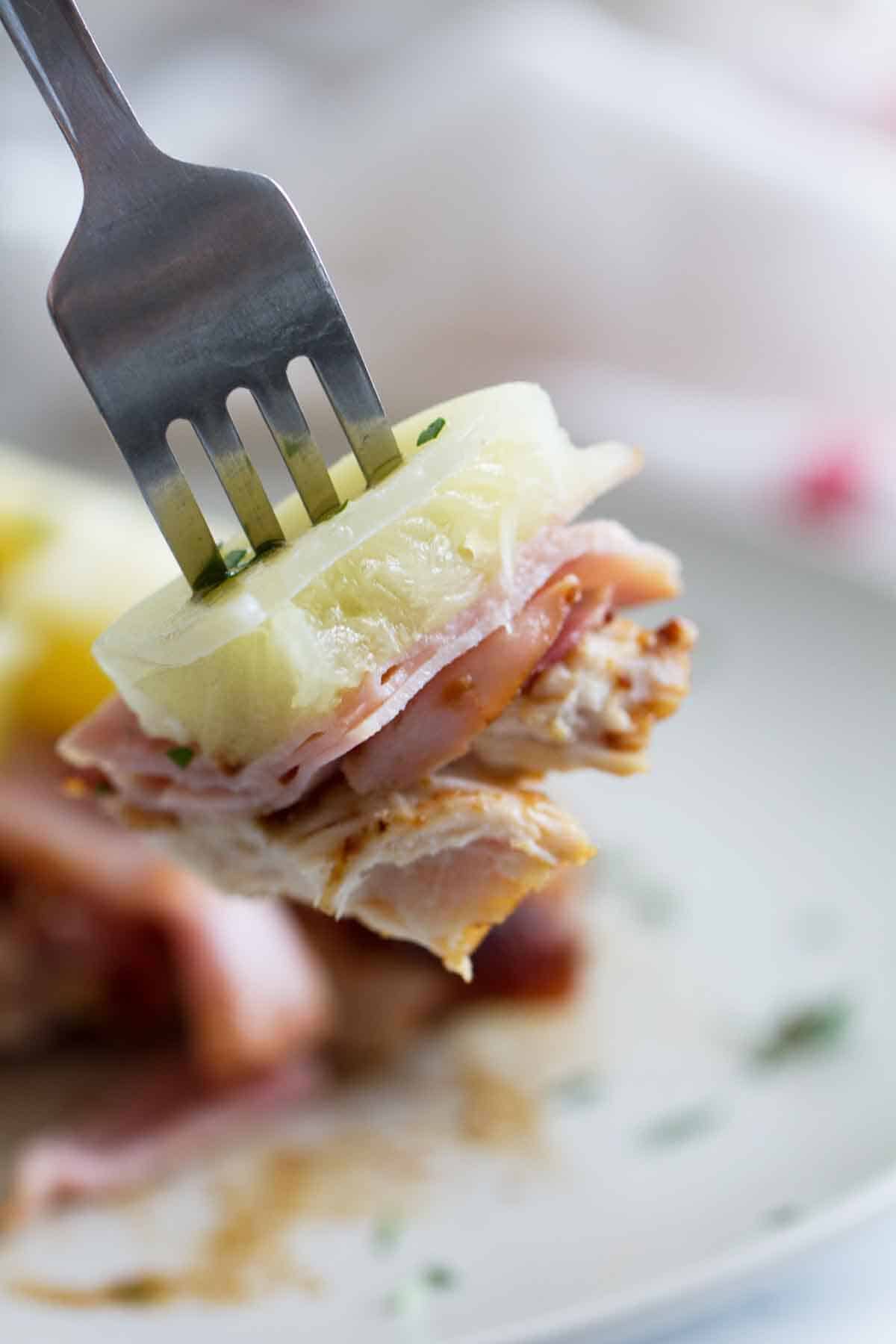 fork with a bite of Hawaiian Chicken with Ham and Pineapple.