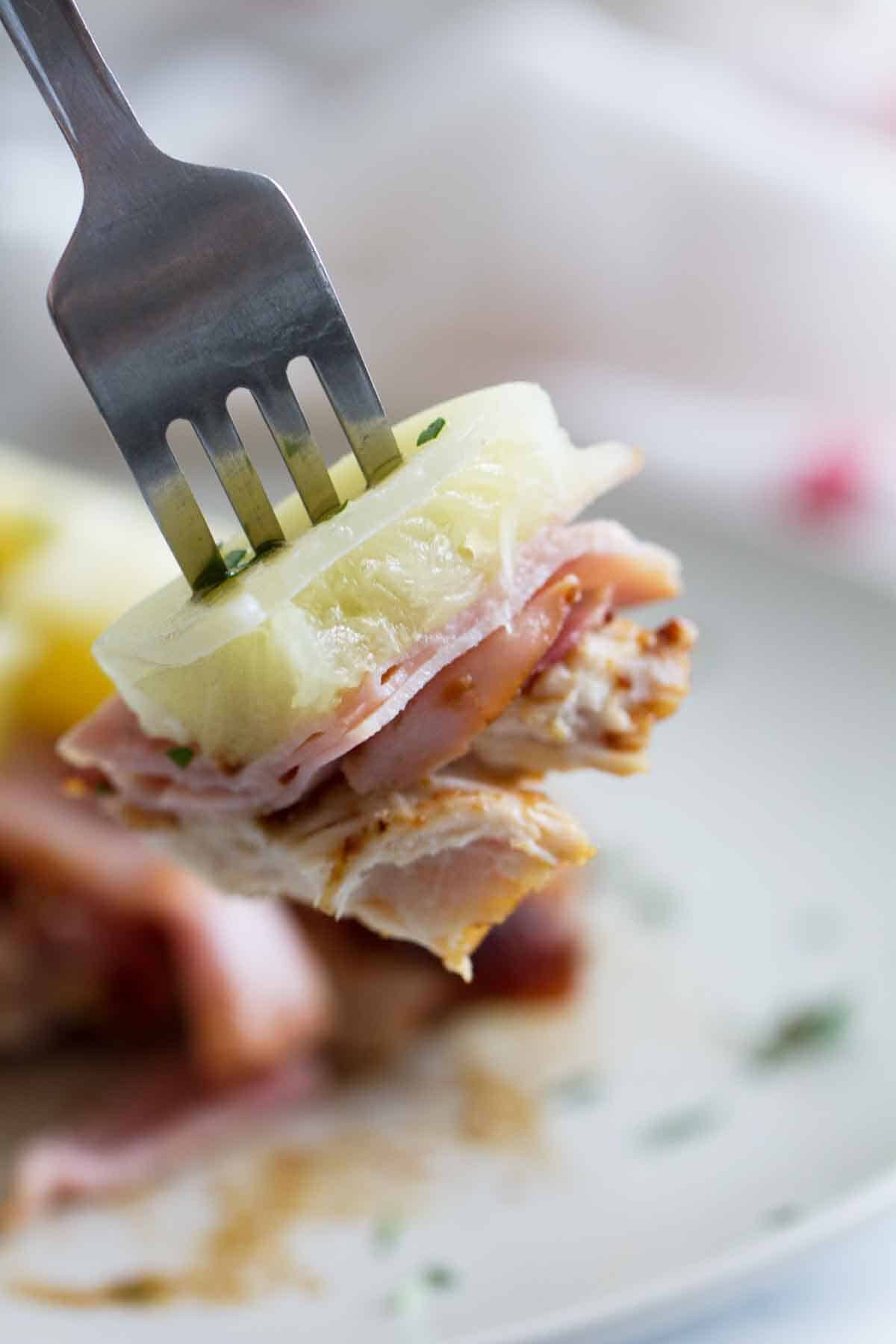 fork with a bite of Hawaiian Chicken with Ham and Pineapple.