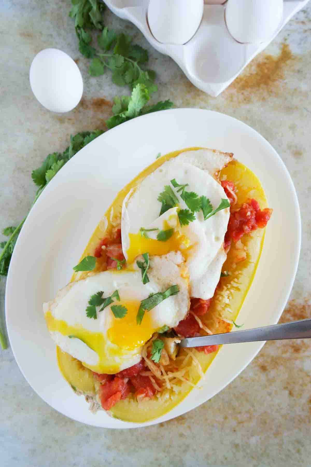 spaghetti squash with tomato sauce topped with 2 fried eggs.