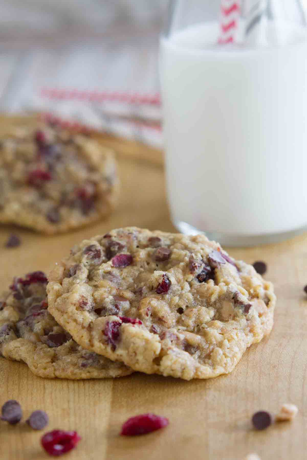 two Oatmeal Cranberry Cookies with Chocolate and Toffee with more in the background.