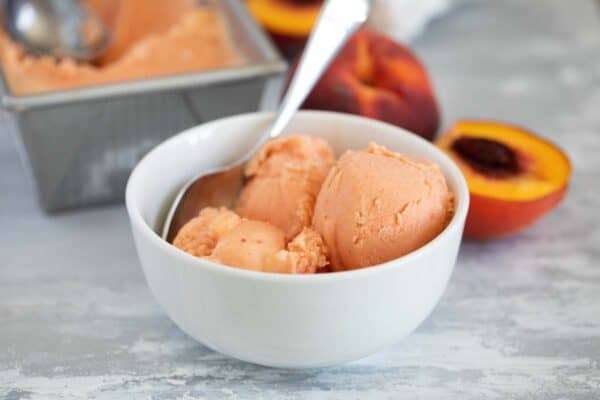 bowl of peach frozen yogurt with a spoon