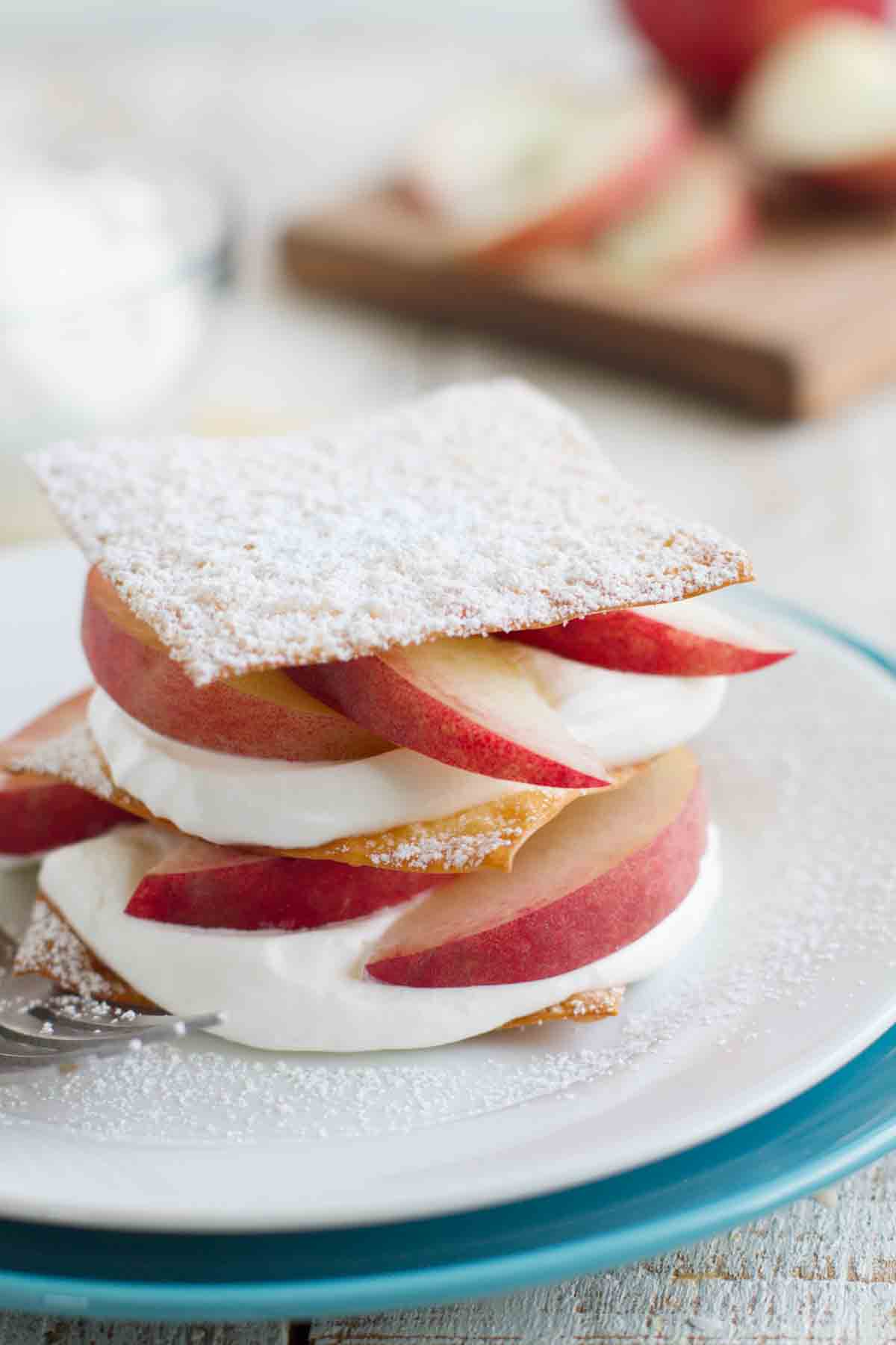 This easy Peach Napoleon Recipe uses baked, sugared wontons that are layered with whipped cream and fresh peaches for a impressive presentation. peach napoleon filled with cream using sugared wonton wrappers
