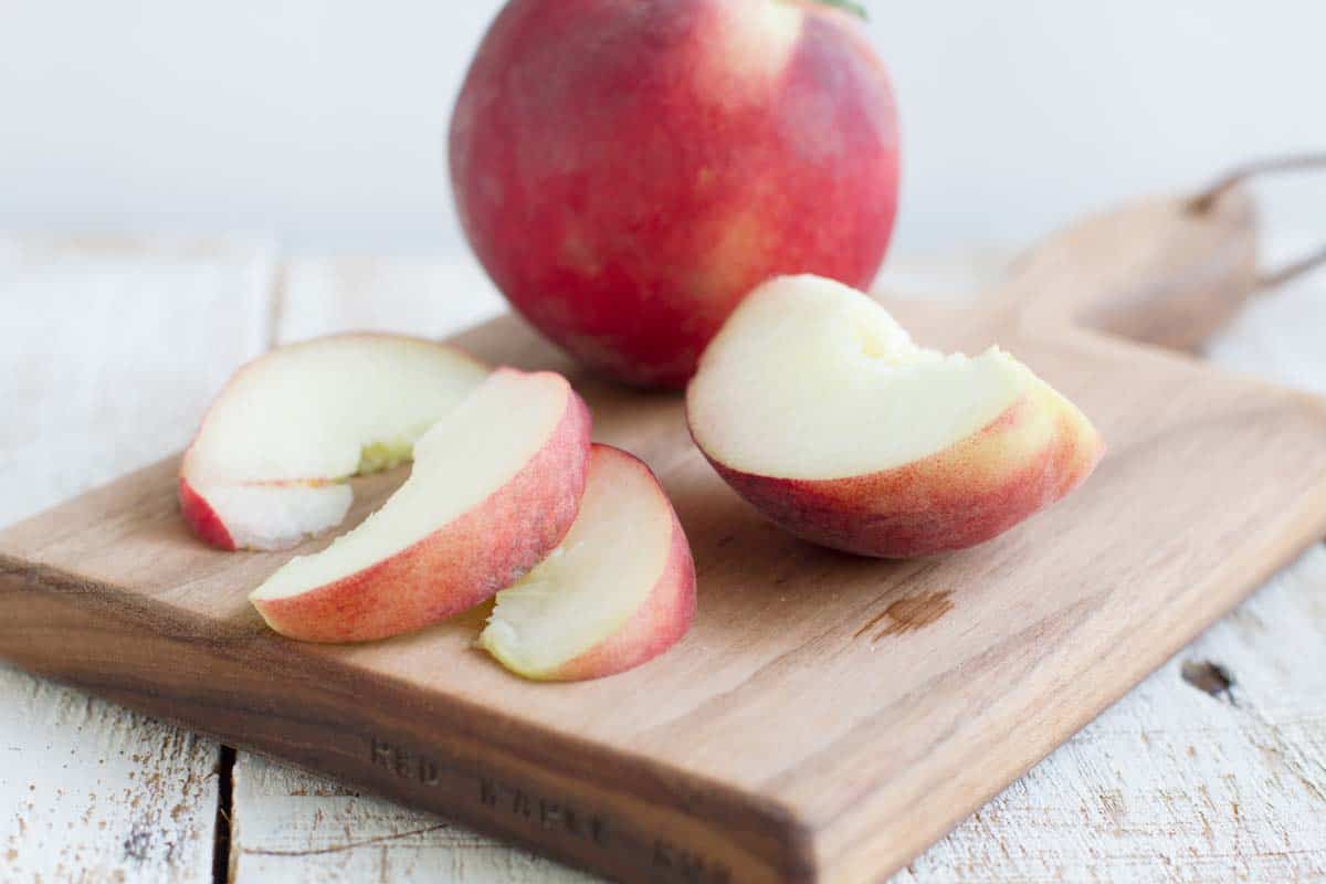 sliced peach on a cutting board